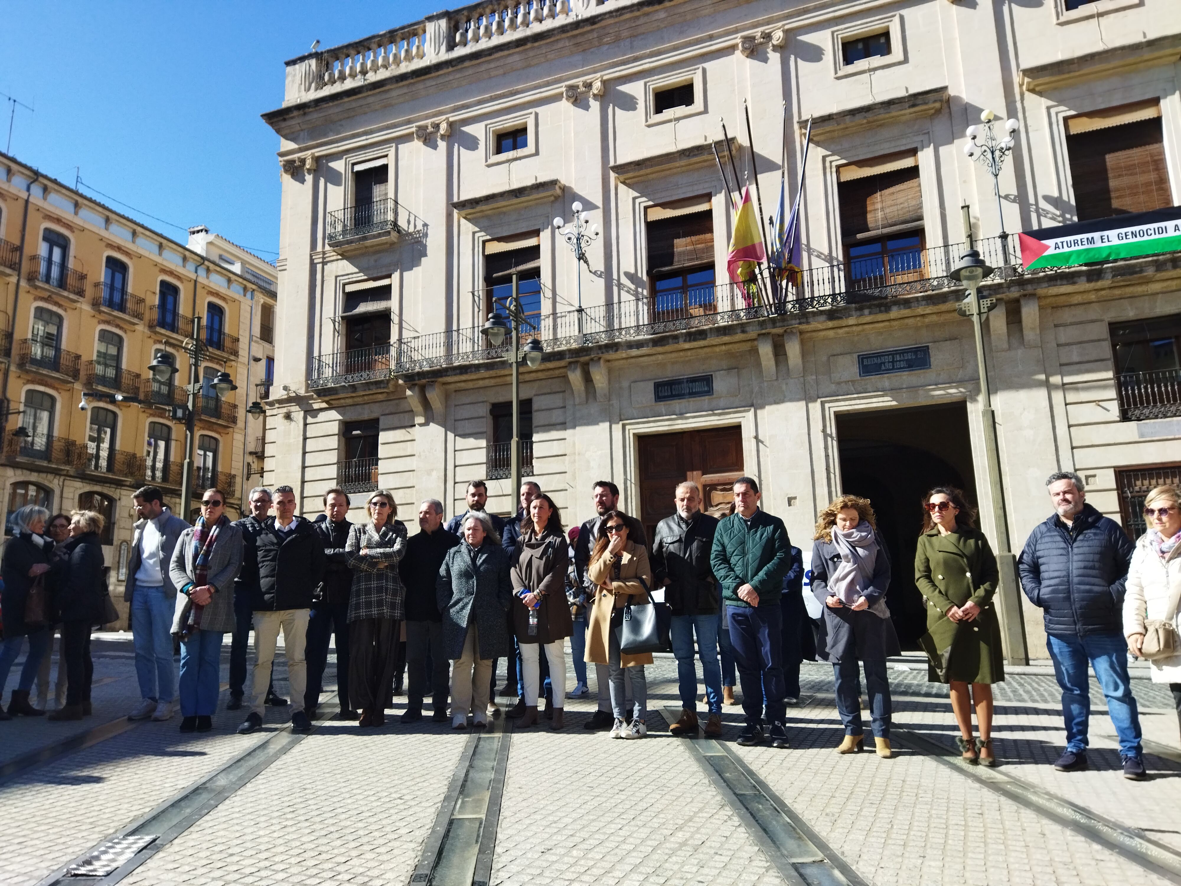 La corporación municipal, encabezada por el alcalde Antonio Francés, en la plaza de España guardando un minuto de silencio en memoria de los fallecidos en el incendio de València.