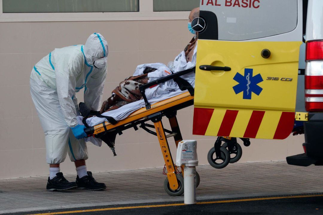 Un sanitario traslada a un enfermo en el Hospital Clínico de València.