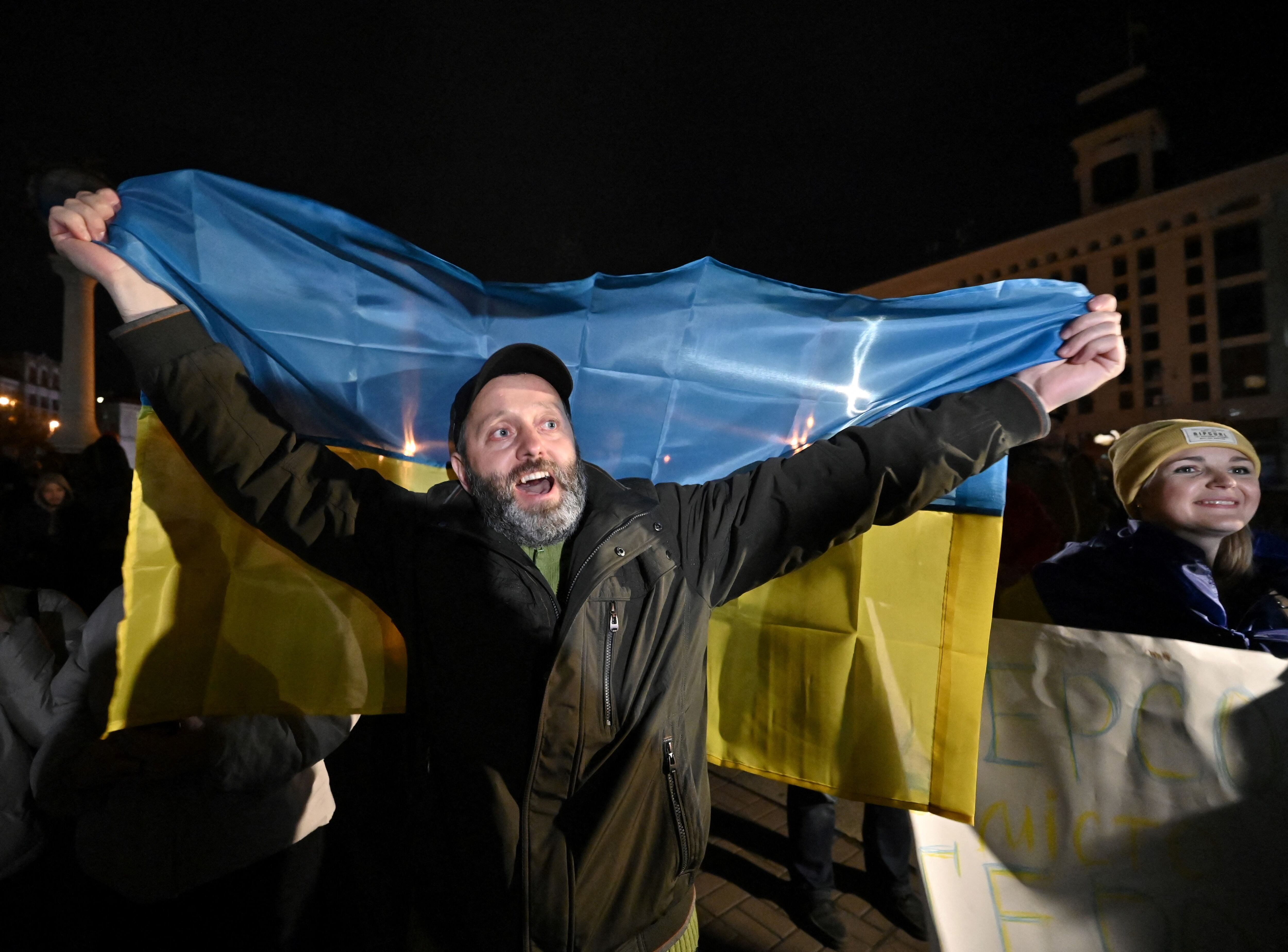 Un hombre sostiene la bandera de Ucrania durante la celebración de la liberación de Jersón, el viernes en la Plaza de la Independencia de Kiev