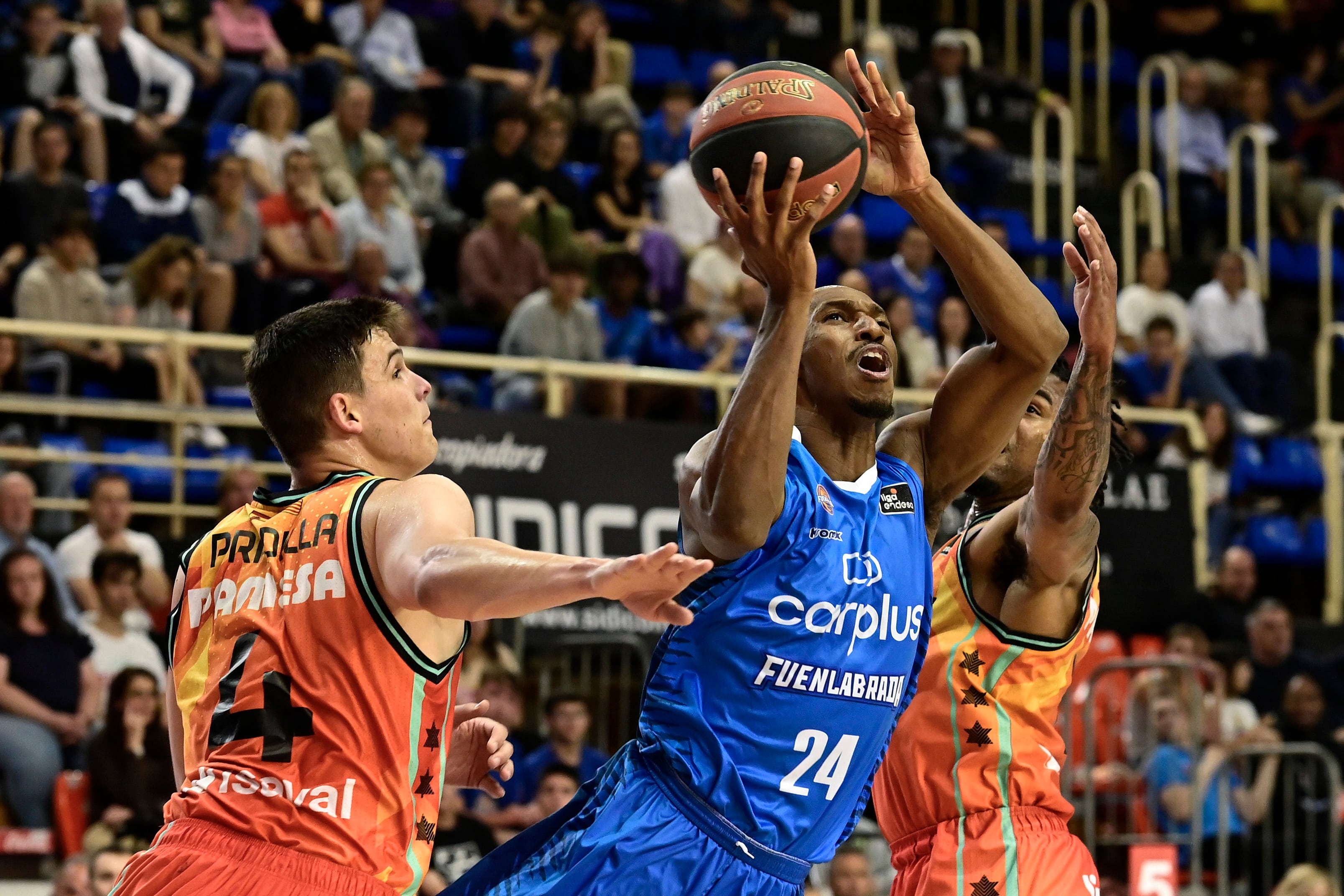 El alero liberiano del Fuenlabrada, Lasan Kromah, con el balón ante los jugadores de Valencia Basket, el ala-pivot Jaime Pradilla y el estadounidense Chris Jones, durante el encuentro correspondiente a la fase regular de la Liga Endesa disputado hoy Domingo en el pabellón Fernando Martín, en Fuenlabrada. EFE / Víctor Lerena.