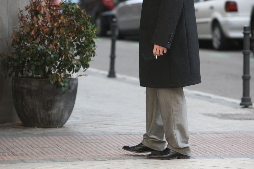 Un hombre fuma en una calle española. 