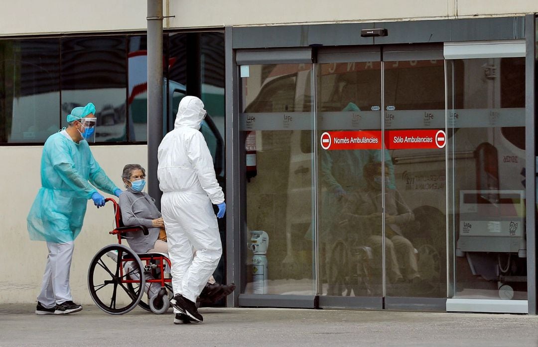 Una mujer ingresa en las urgencias del hospital La Fe de Valencia este domingo de Ramos, en el vigésimo segundo de confinamiento. 