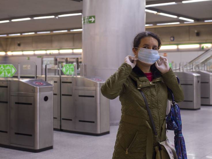 Usuaria poniéndose la mascarilla para subir al Metro