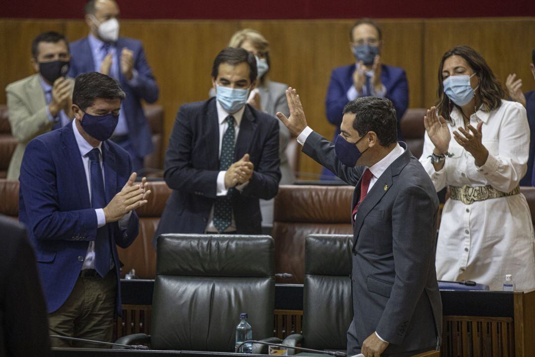 El presidente de la Junta de Andalucía, Juanma Moreno (d), junto al vicepresidente de la Juntam Juan MArín (i), aplaudido por la bancada del grupo parlamentario popular tras su intervención en la segunda jornada del Debate sobre el Estado de la Comunidad en el Parlamento de Andalucía