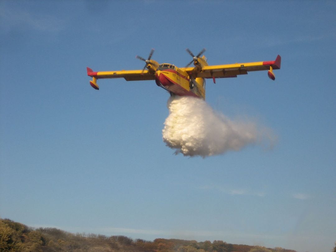 Un hidroavión del tipo &quot;CanadaAir&quot; realiza una descarga sobre un incendio forestal