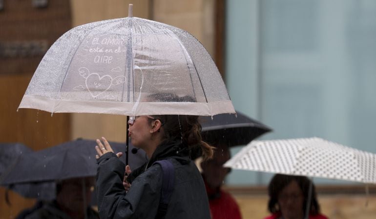 Un grupo de turistas se protege con paraguas de las incesantes lluvias que se registran en San Sebastián, la capital guipuzcoana.