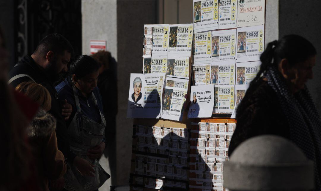 Personas comprando décimos de la lotería del Niño.