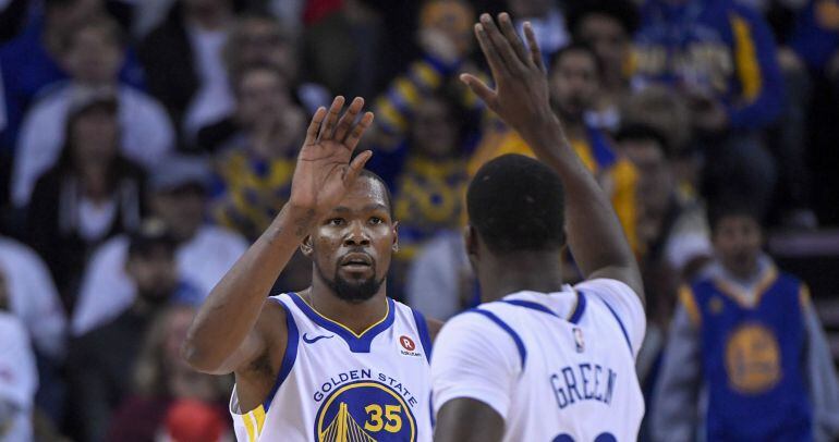 Kevin Durant y Draymond Green, a punto de chocarse las manos durante el partido
