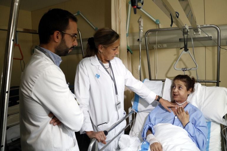 Una pareja de médicos atiende a una paciente en un hospital de Cataluña. 