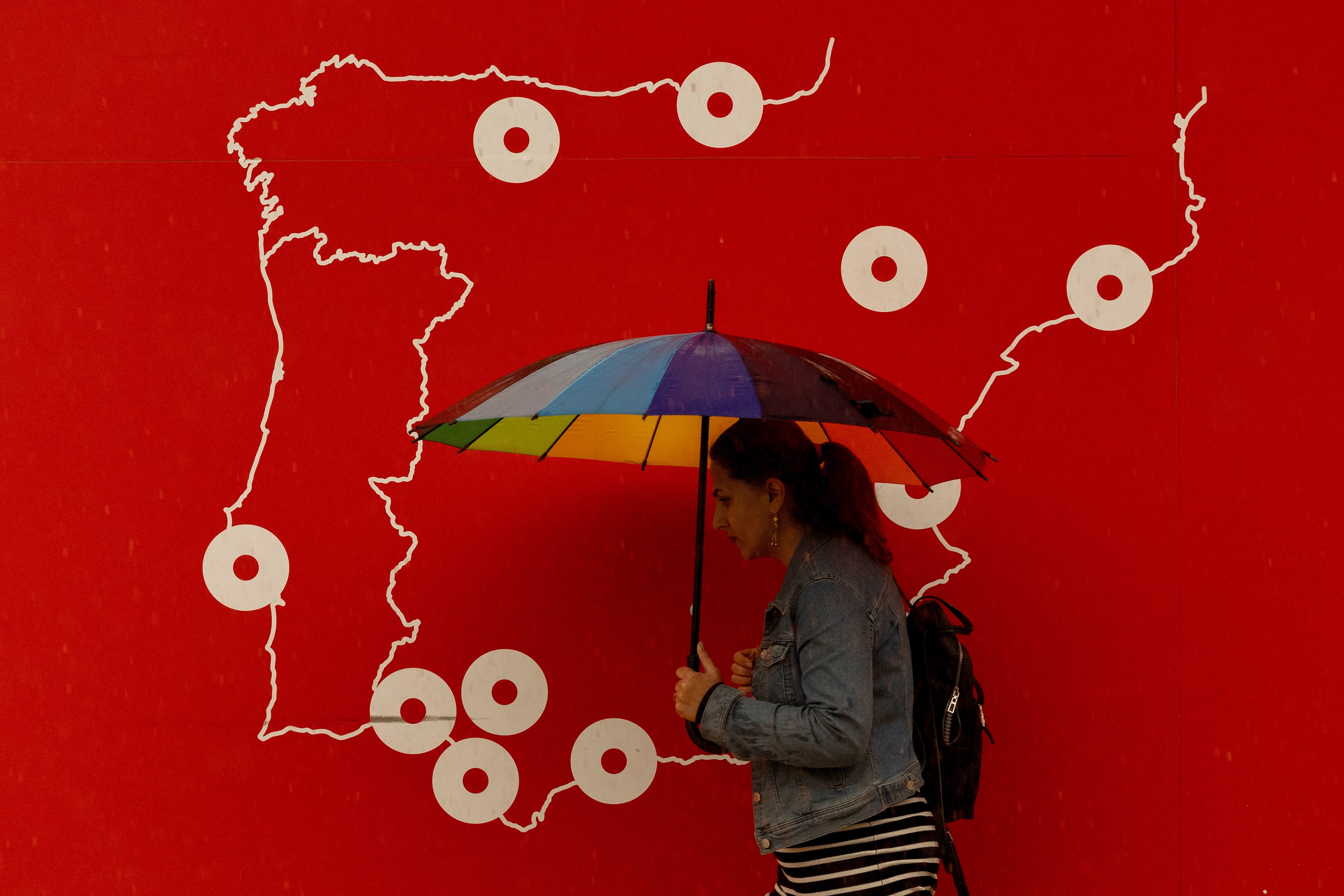 GRAFAND4157. MÁLAGA, 29/10/2024.-Una mujer se resguarda de la lluvia bajo un paraguas este martes en Málaga