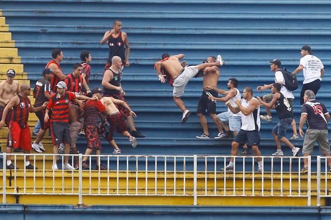 Aficionados del Atlético Paranaense y Vasco da Gama se enfrentan durante un partido de la última jornada del Campeonato Brasileño, dejando al menos tres hinchas gravemente heridos en la Arena Joinville en la ciudad de Joinville (Brasil)