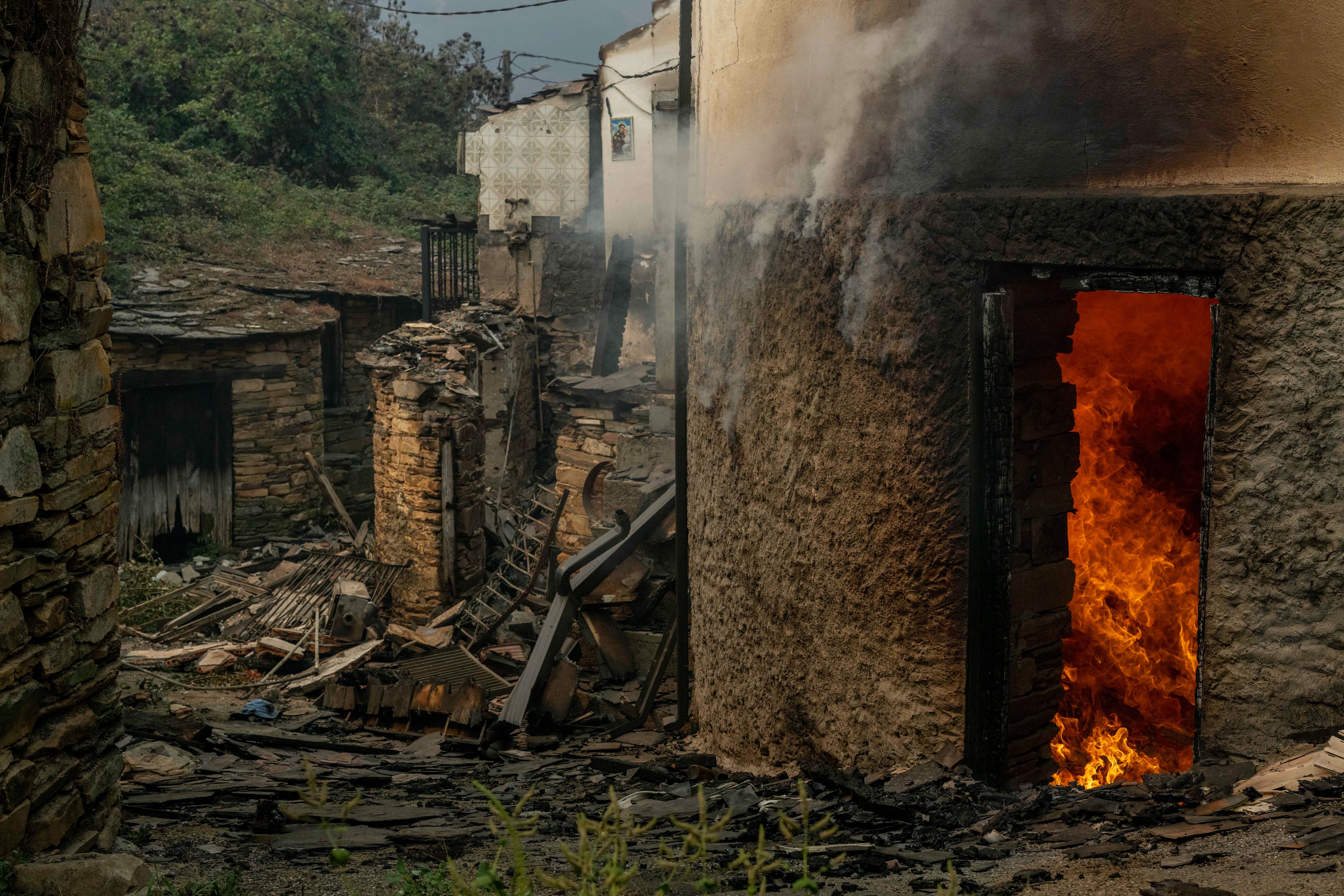 VILAMARTÍN DE VALDEORRAS (OURENSE), 18/08/2025.- Vista de viviendas ardiendo en la aldea de San Vicente, este lunes en Vilamartín de Valdeorras (Ourense). Toda la provincia de Ourense continúa en situación 2 de emergencia y el tráfico ferroviario entre Galicia y Madrid sigue interrumpido. EFE/ Brais Lorenzo
