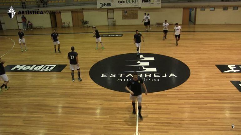 Los jugadores del Villa de Aranda, calentando sobre el parqué portugués