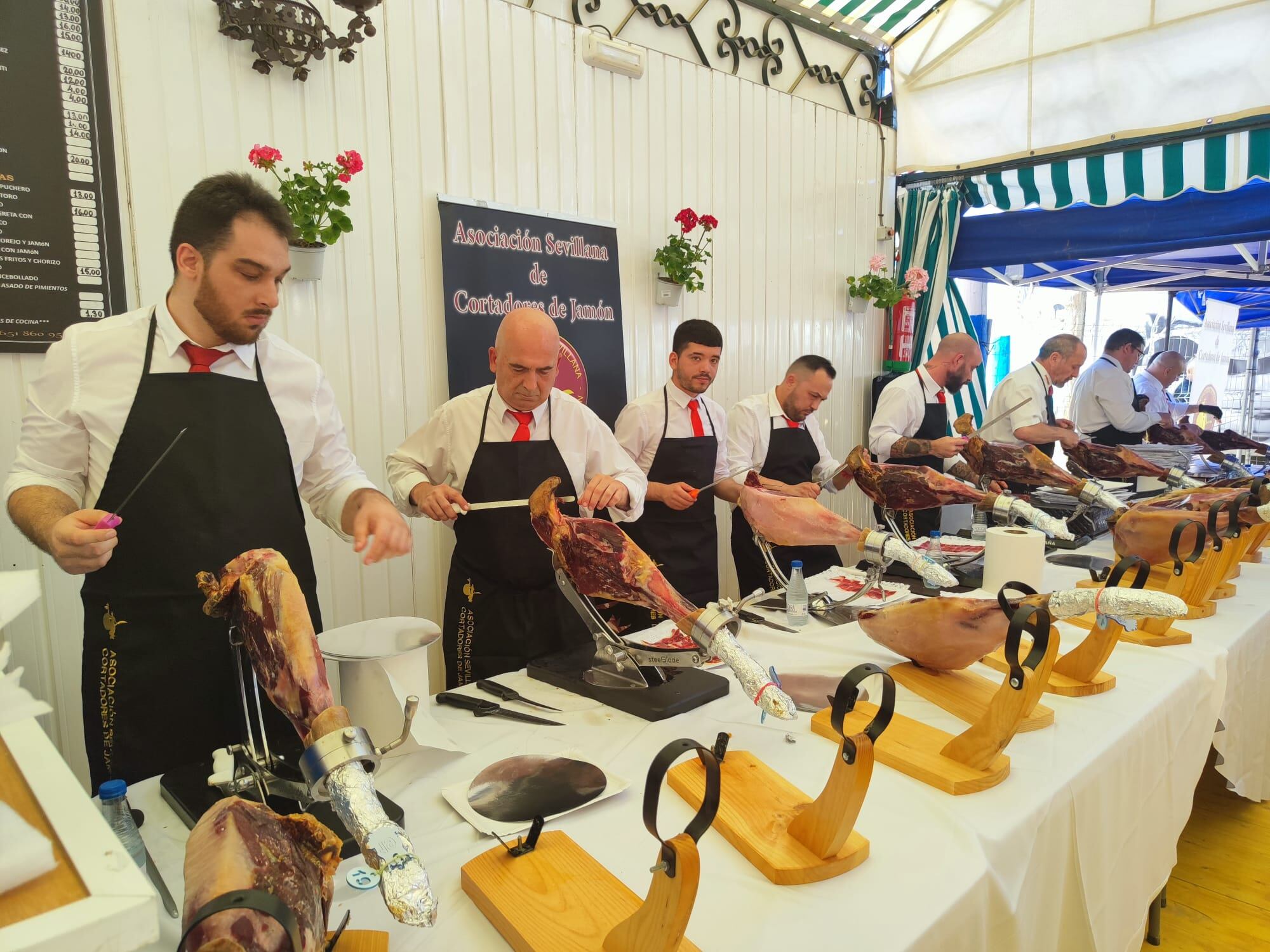 Cortadores de jamón en el concurso para elegir la mejor pieza organizado por Asociación de la Cabalgata de Reyes Magos Silos, en la Feria de Alcalá de Guadaíra 2024