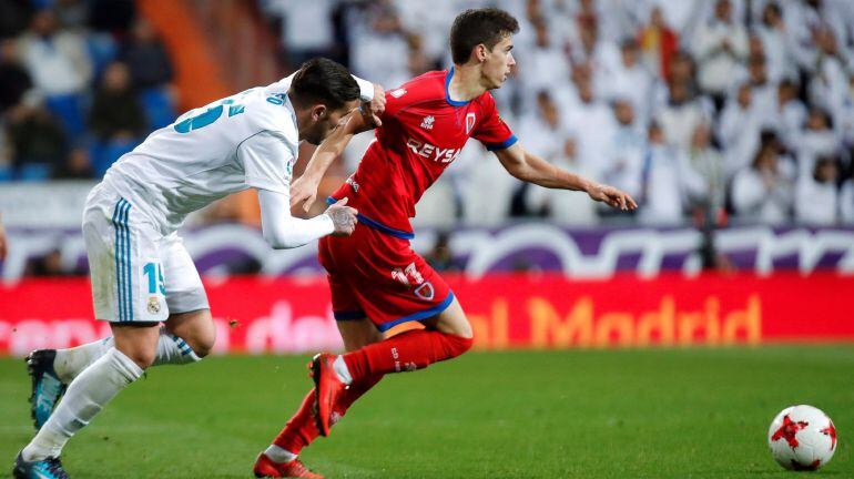 El centrocampista del Numancia, Ignacio Agustín Sánchez &quot;Nacho&quot;, se lleva el balón ante el acoso del defensa francés del Real Madrid, Theo Hernández