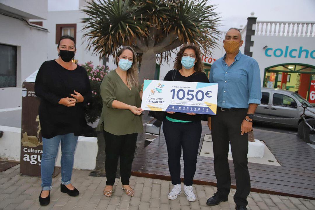 La consejera de Comercio del Cabildo de Lanzarote, Carmen Guadalupe, entregando el premio a la ganadora junto a la concejal de Comercio de Tías, Kalinda Pérez.