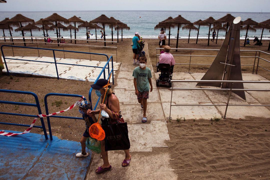Varias personas en uno de los puntos de accesos a la playa de la Malagueta. La provincia de Málaga ultima los preparativos para pasar este lunes a la fase 2 de la desescalada del confinamiento por la pandemia de coronavirus, en la que una de las novedades será la reapertura de las playas para el baño y el uso.