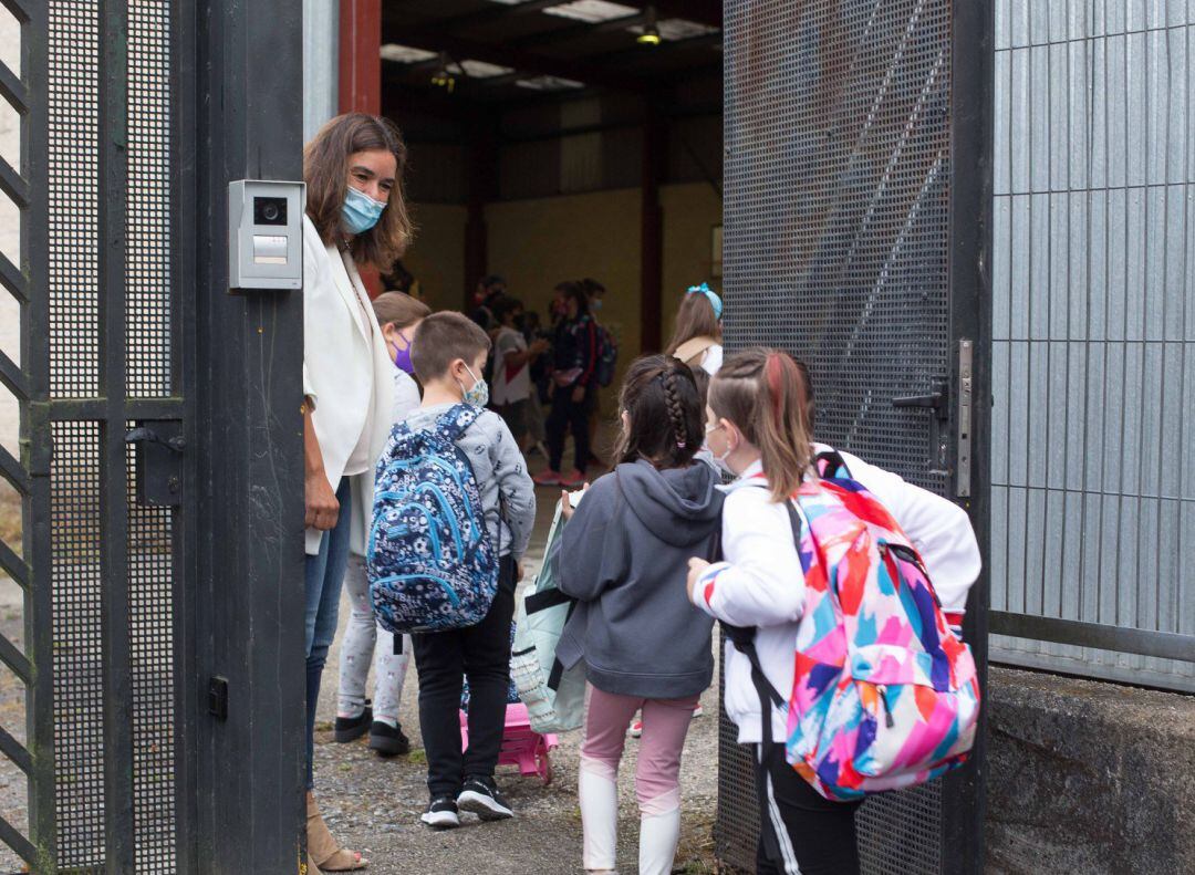 Varios niños y niñas entran al colegio