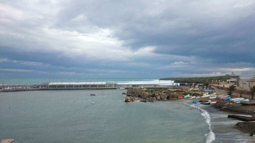 Vista de la isla de Tabarca, con varias barcas de pesca en la orilla y la zona de restauración al fondo.