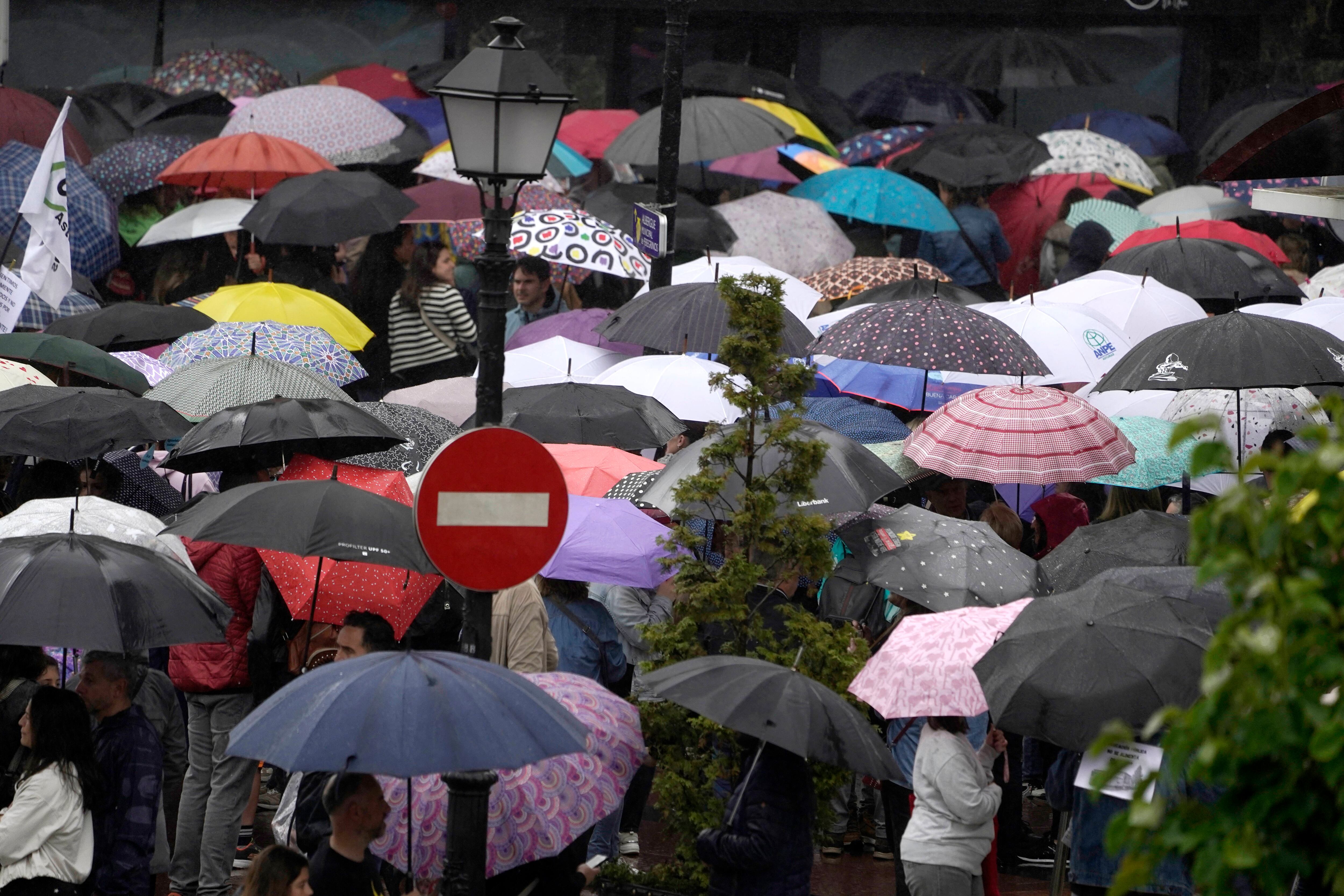 Decenas de personas se protegen de la lluvia en Oviedo.
