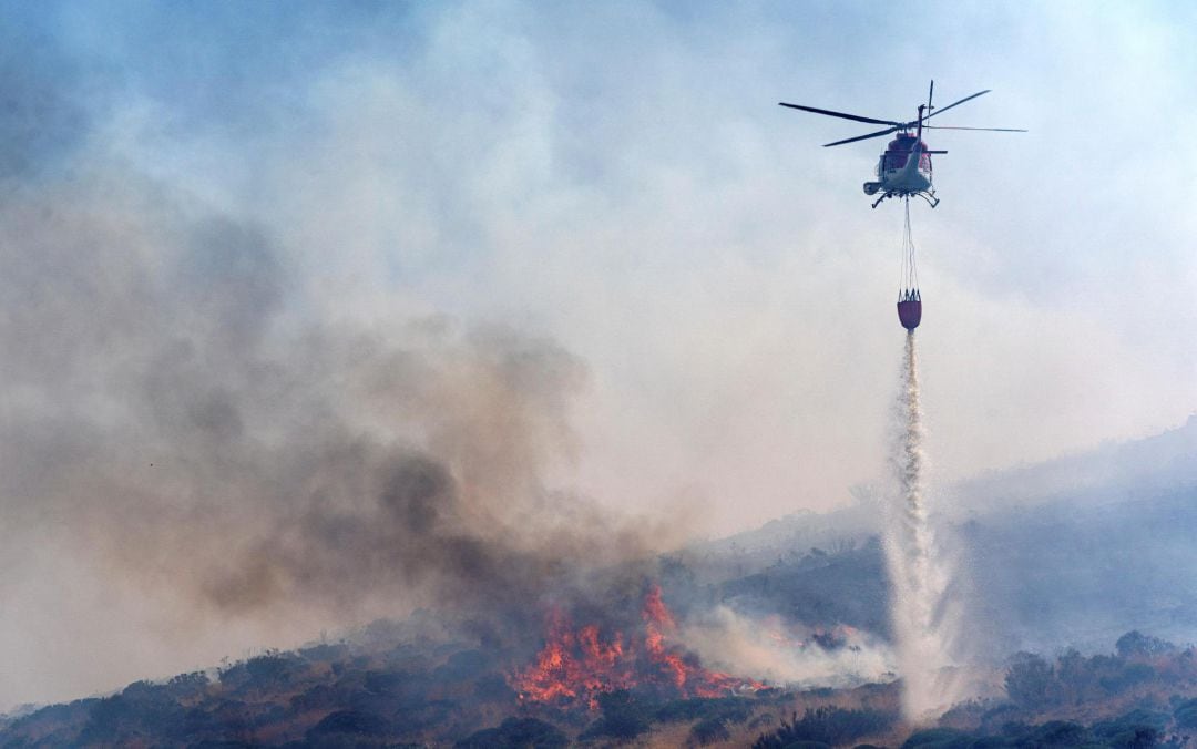 Los bomberos tratan de sofocar un incendio originado al prenderse un vehículo a la altura del kilómetro 39 de la N-502 de Ávila este sábado