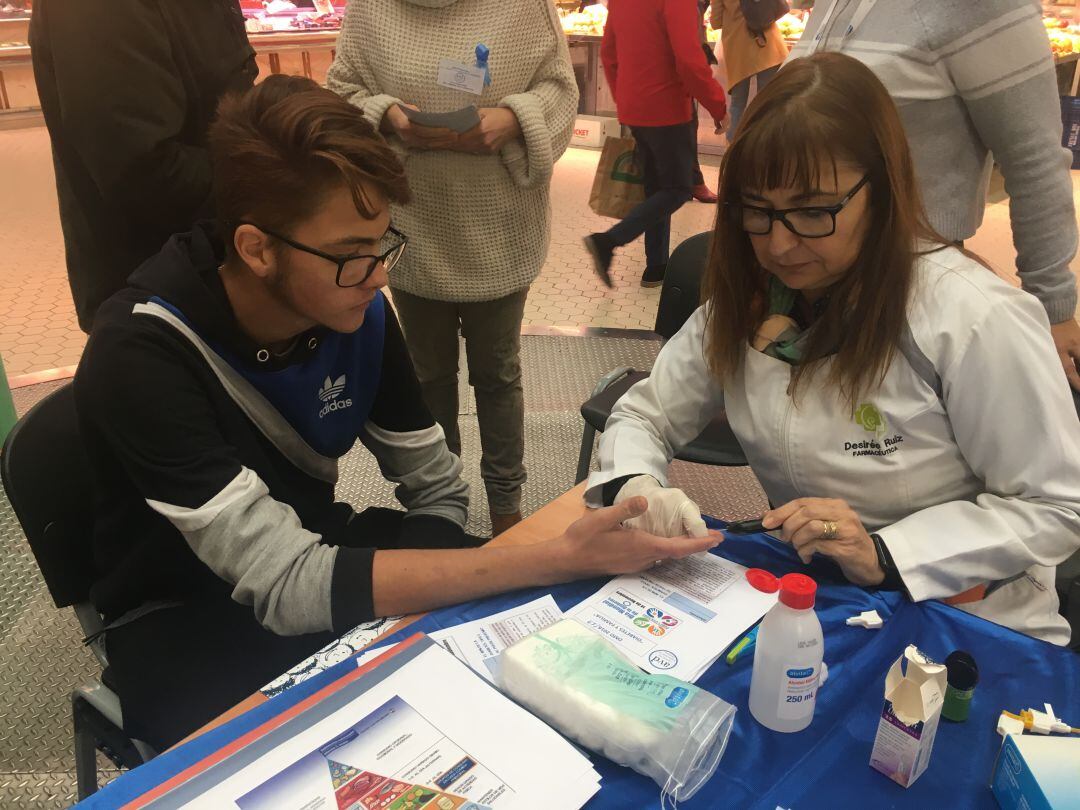 Una enfermera realiza el test de glucemia a un joven