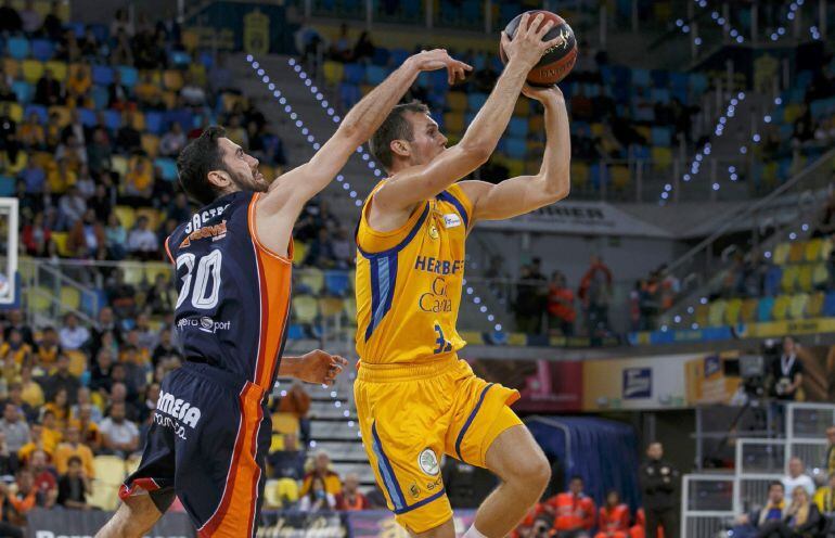 El base serbio de Herbalife Gran Canaria, Nikola Radicevic, entra a canasta ante el escolta de Valencia Basket, Joan Sastre, durante el segundo encuentro de los Playoffs de la liga Endesa disputado esta noche en el Gran Canaria Arena