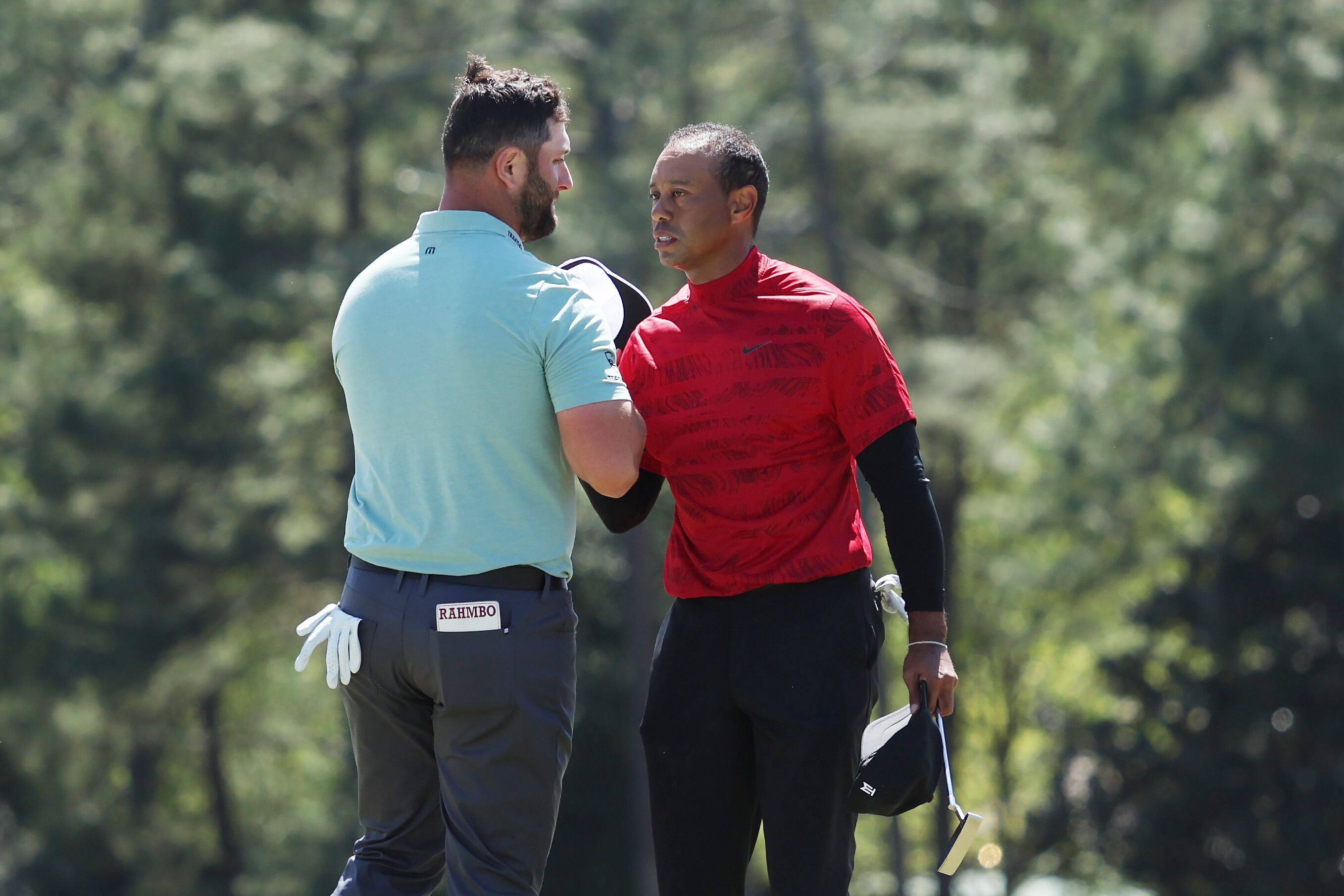 Jon Rahm y Tiger Woods se saludan al inicio de la última jornada del Masters de Augusta