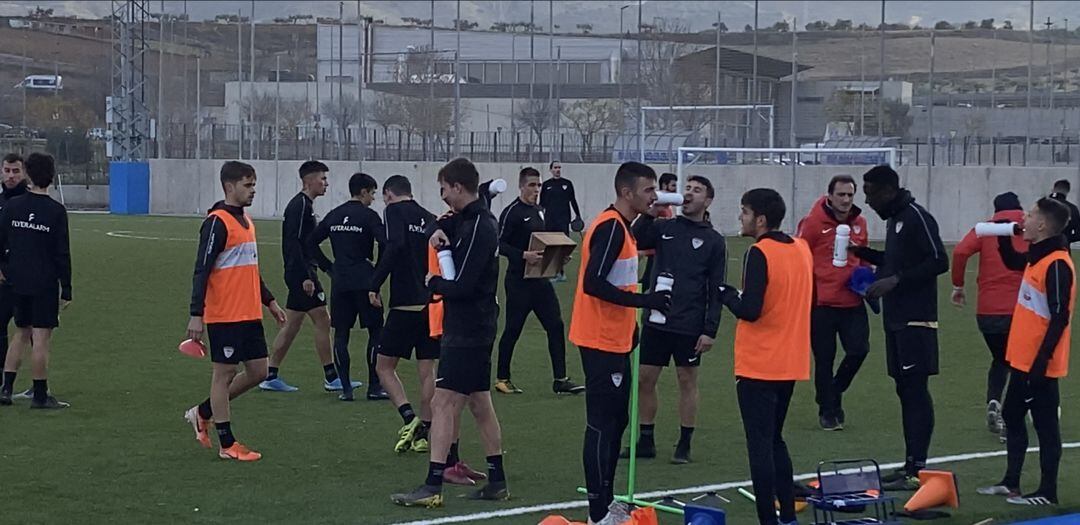 Los jugadores morados se refrescan durante un entrenamiento.