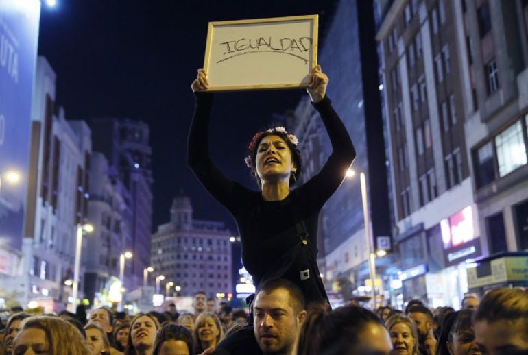 Una de las mujeres de la marchas del Día del la Mujer en 2017 sostiene una pizarra pidiendo igualdad 