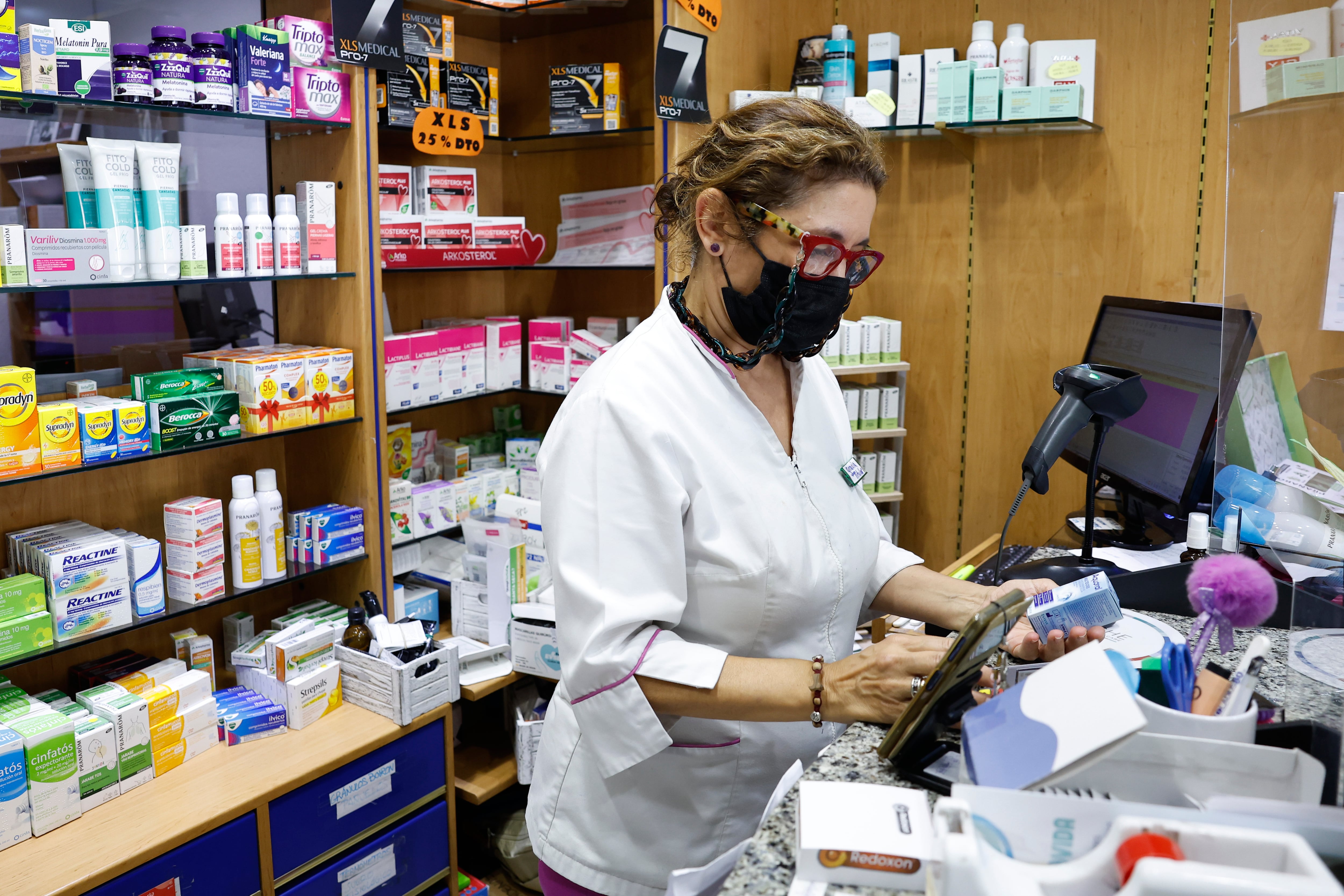 MADRID, 04/07/2023.- Una dependienta de una farmacia de Madrid, se protege este martes con una mascarilla. Las mascarillas ya no serán obligatorias en centros sanitarios, sociosanitarios y farmacias de España, según un acuerdo aprobado este martes por el Gobierno español, que declara la finalización de la situación de crisis sanitaria ocasionada por la covid-19.EFE/Chema Moya
