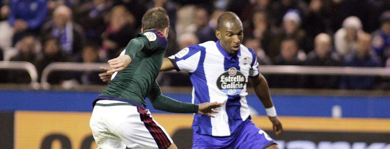 El delantero holandés del Deportivo Ryan Babel disputa un balón con el centrocampista serbio Goran Causic, del Osasuna.