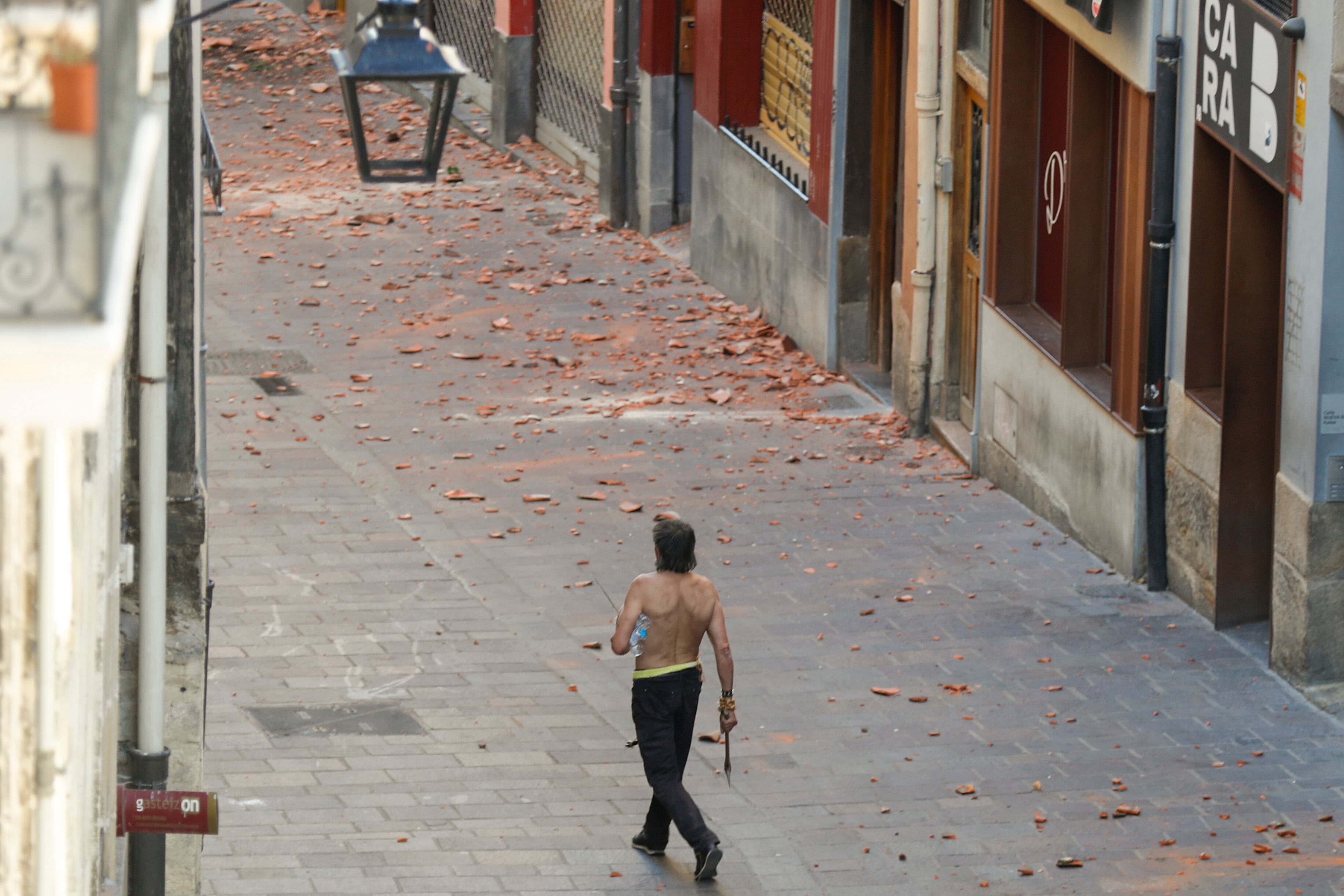 El hombre que se ha atrincherado en su piso en el Casco Viejo de Vitoria, camina por la calle armado con un hacha.