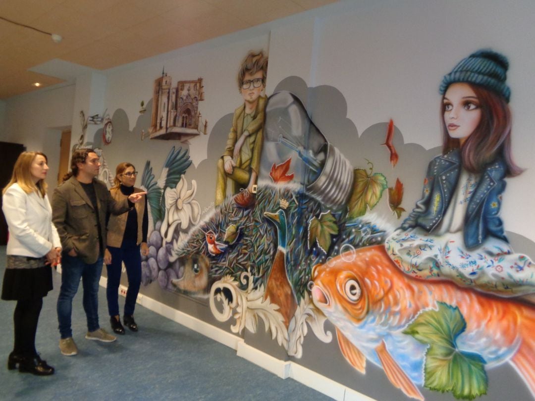 El autor explica las características del mural a la concejal, Celia Bombín, y la alcaldesa