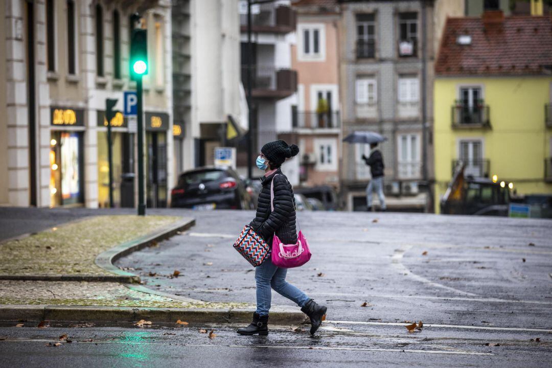 Una mujer camina por las calles de Lisboa.