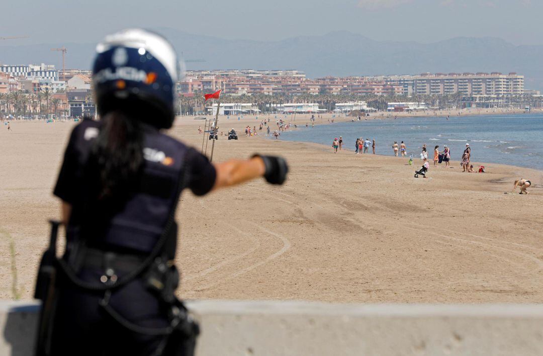 Una agente de la Policia Nacional realiza labores de control en la playa de la Malvarrosa durante la fase 1 de la desescalada en València.