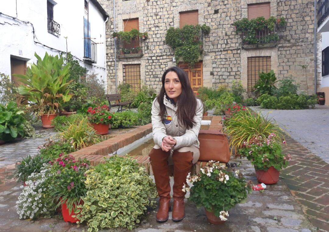 Mónica Moreno posa sentada en la fuente de estilo árabe, rodeada de macetas en la plaza del Convento, antaño llamada de Santa María de Iznatoraf, uno de los lugares mas fotografiados del espectacular casco urbano de esta población situada a más de mil met