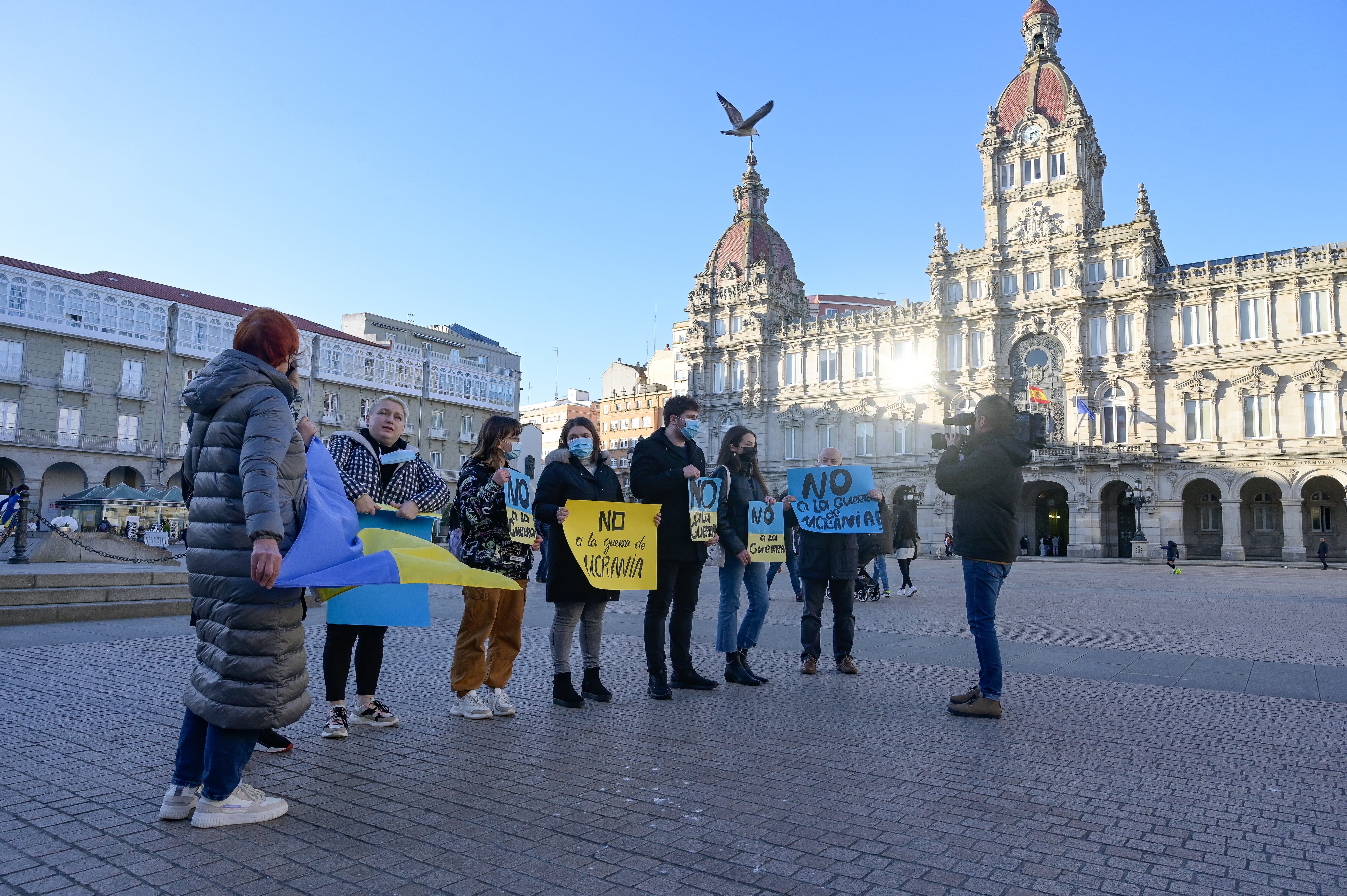 A CORUÑA, 25/02/2022.- Varias personas participan en una concentración en la Plaza de María Pita de residentes ucranianos en A Coruña, este viernes. EFE/Moncho Fuentes