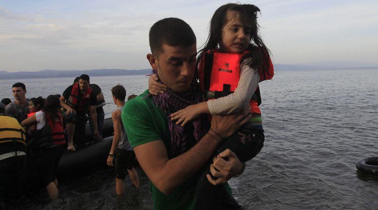 Ciudadanos sirios llegan en una lancha neumática a la isla de Lesbos, Grecia, tras cruzar el Mar Mediterráneo