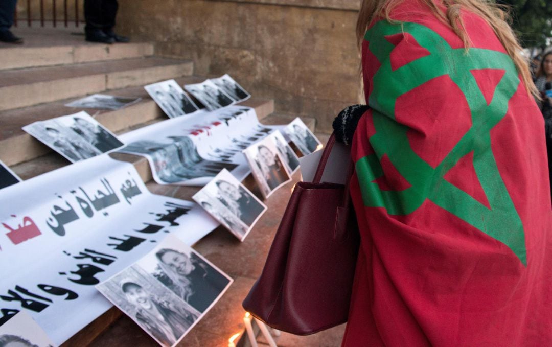 Una mujer coloca velas junto a las fotografías de dos turistas asesinadas en Marruecos, en la Catedral de San Pedro en Rabat (Marruecos)