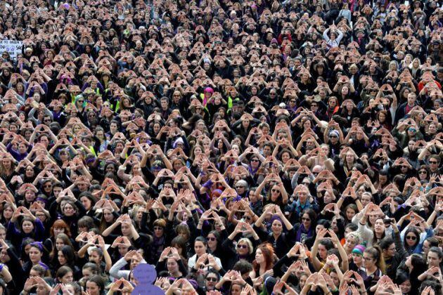 Los manifestantes forman triángulos con sus manos durante una manifestación por los derechos de las mujeres