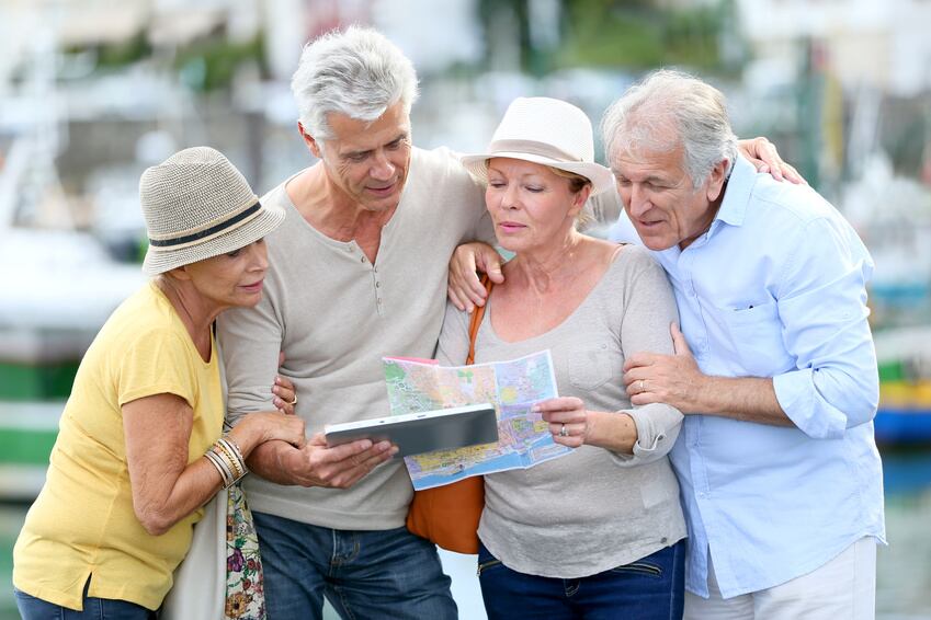 Senior tourists using tablet on visiting jourViajes Club de los 60ney