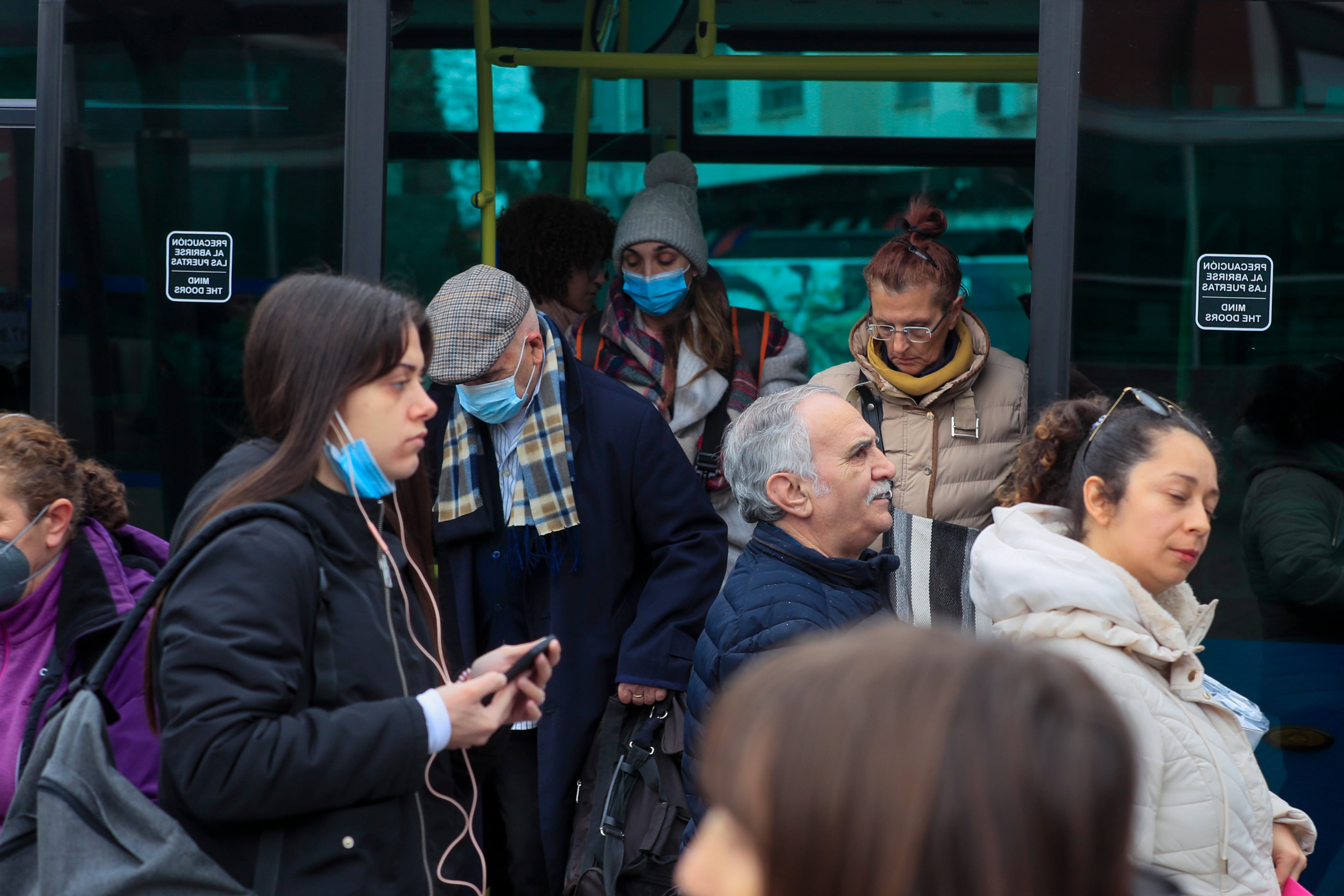 Pasajeros con y sin mascarilla bajan de un autobús en el primer día en el que se pudo ir en el transporte público sin mascarillas, obligatoria desde mayo del 2020 y el símbolo más significativo de la pandemia de la covid.