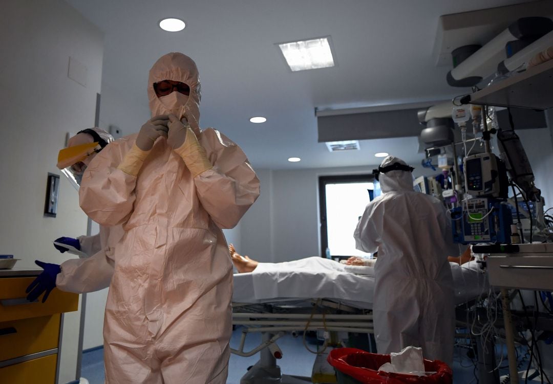 Personal sanitario con un paciente de COVID-19 en la UCI. 