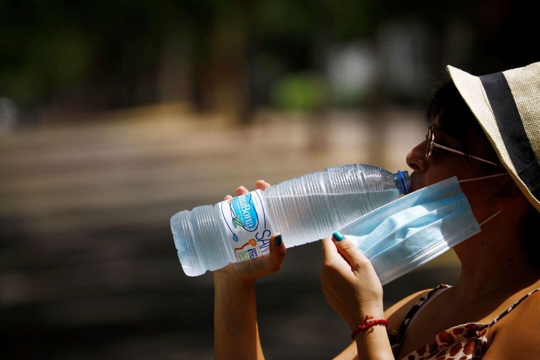 Una mujer se hidrata para aliviar las altas temperaturas