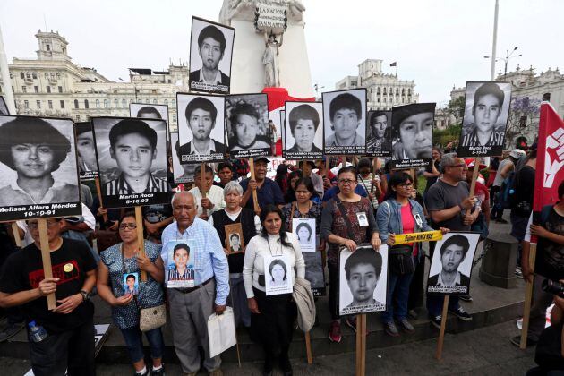 Familiares de víctimas del conflicto con la guerrilla en los años 80 y 90 portan sus fotos