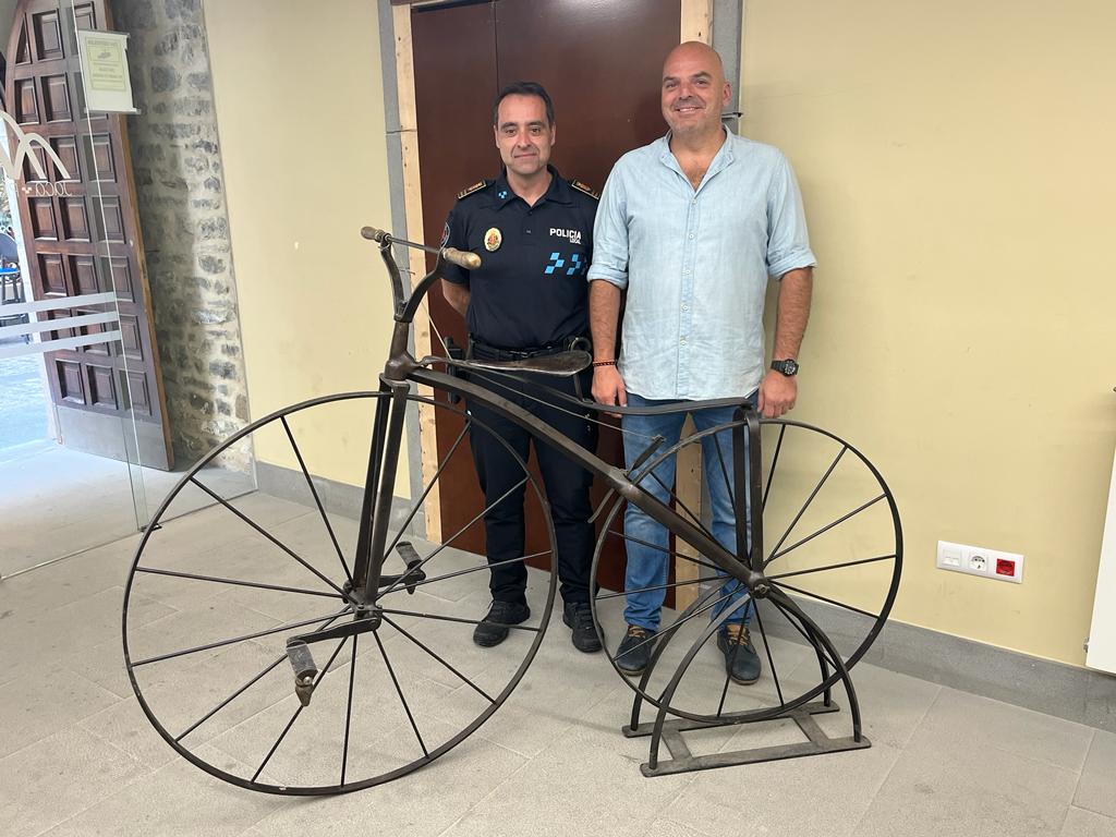 El concejal, Sergio Cajal, y el jefe de la policía loca, César Ara, junto a la bicicleta antigua expuesta en el hall del Ayuntamiento