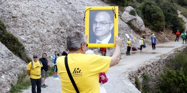 Un participant aixeca la fotografia de Jordi Turull abans de passar-la a una altra persona de la cadena. 28 d&#039;abril de 2018. (Horitzontal)