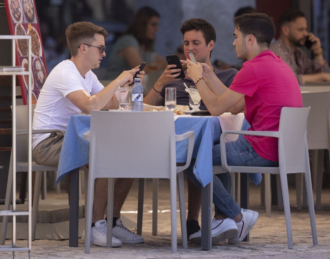 Tres hombres comen en una terraza del centro de Madrid.