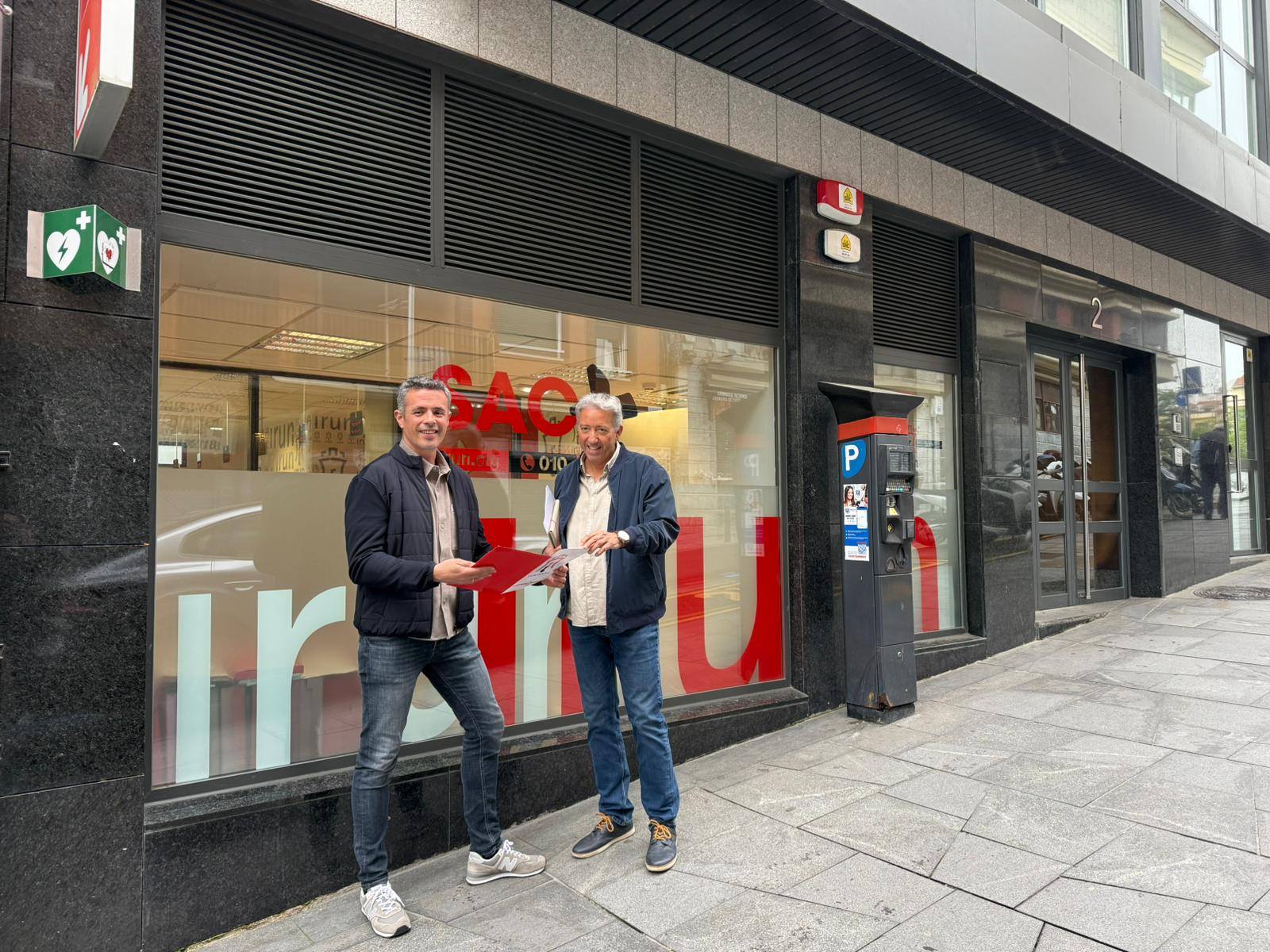 Jon Ugarte, delegado de Gobierno Abierto y Atención Ciudadana, y Pedro Alegre, director del área de Participación Ciudadana frente a las oficinas del SAC